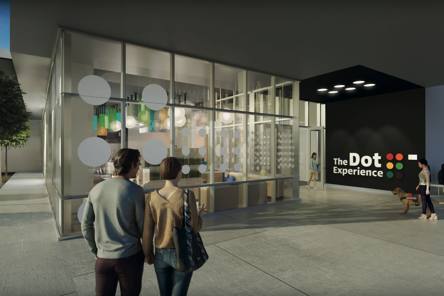 Exterior view of The Dot Experience, a modern building with tall glass windows decorated with circular patterns. Inside, colorful hanging lights are visible. Two people stand in the foreground holding hands while looking at the entrance. The black wall at the entrance displays the logo reading 'The Dot Experience' with a row of colored dots. Nearby, a woman walks a service dog, and two people sit on a bench by the wall.
