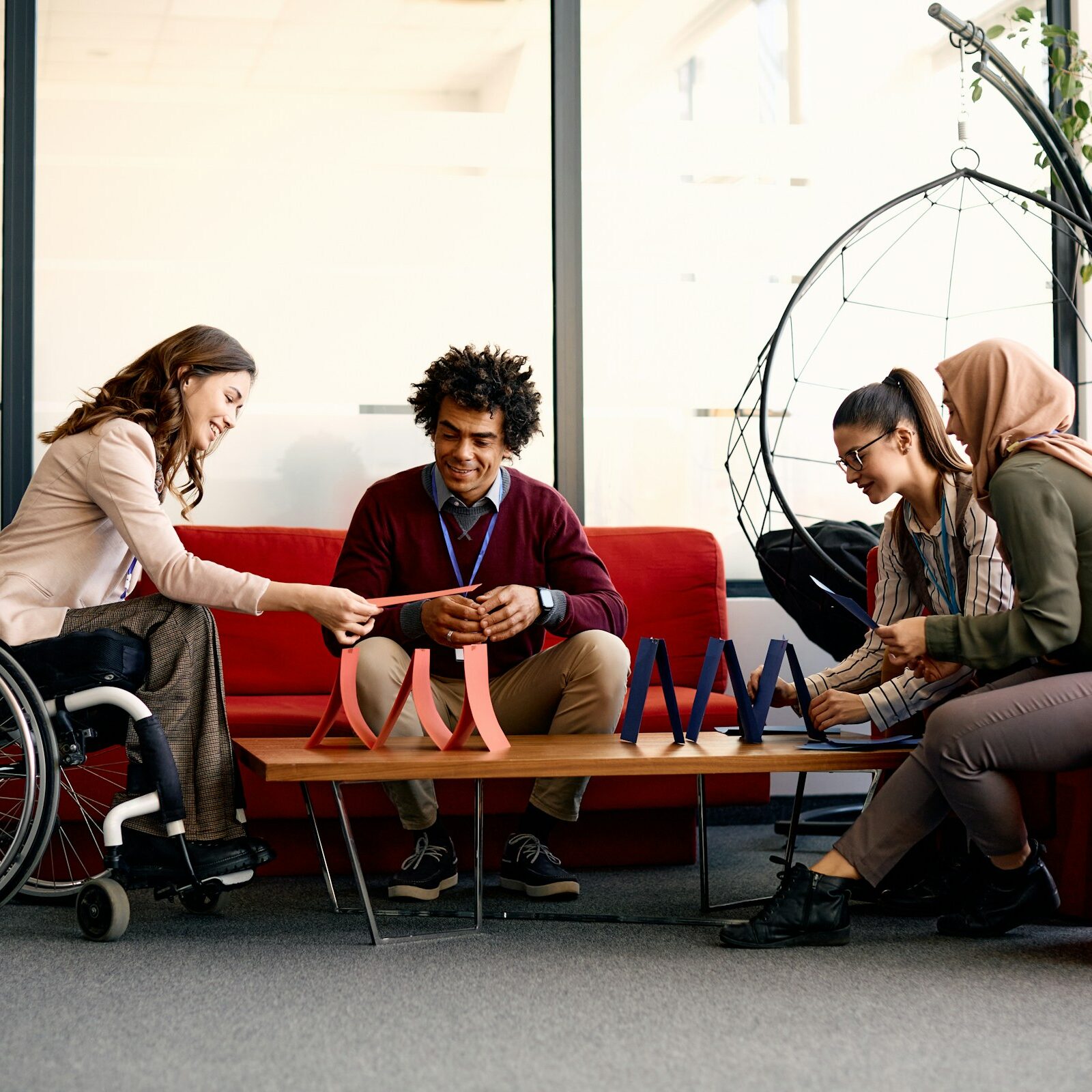 Four people sitting together around a table, playing a game.