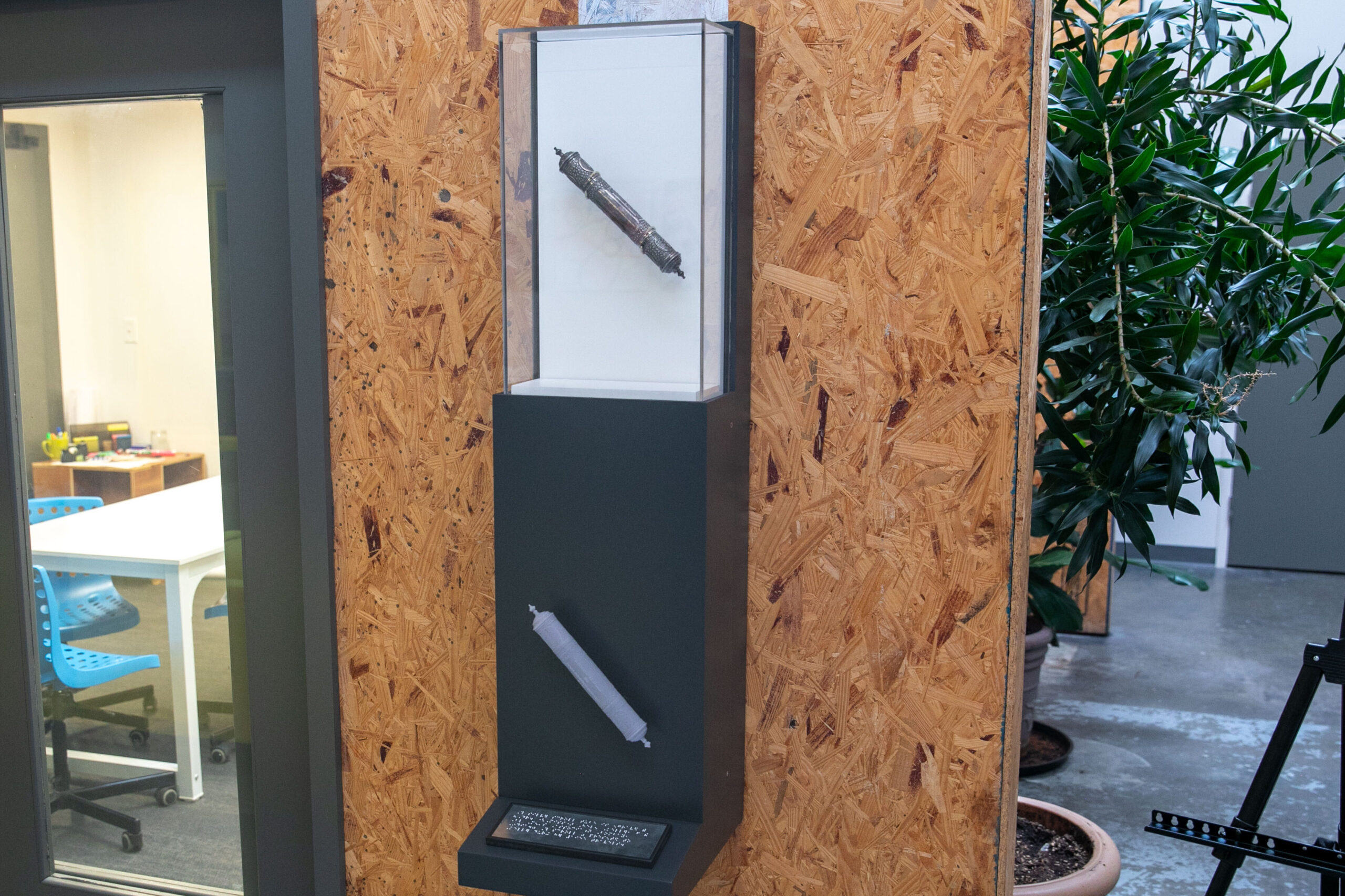 The black and white photos shows Helen Keller and her translator talking with two men. The men are wearing military uniforms and both women are wearing dresses and hats. Helen has her hand on one gentleman's face, feeling the outline of his lips, and is smiling.