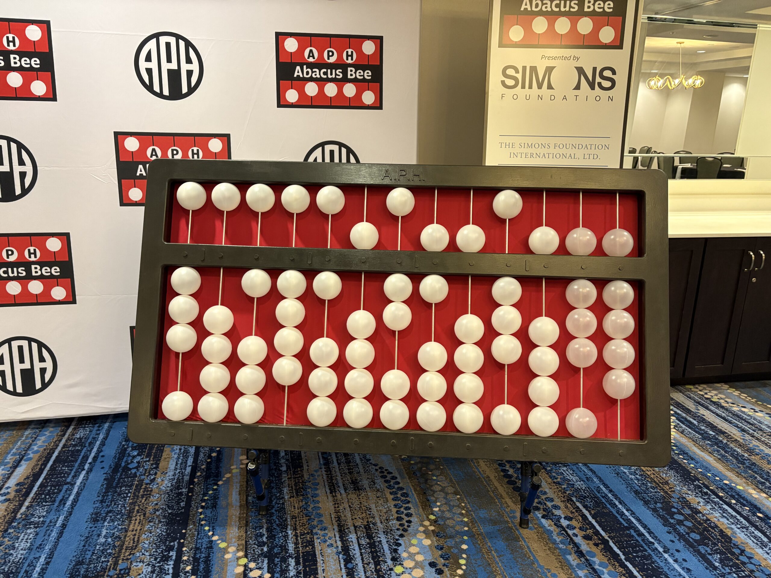 An extra large Abacus sits in front of an APH banner.