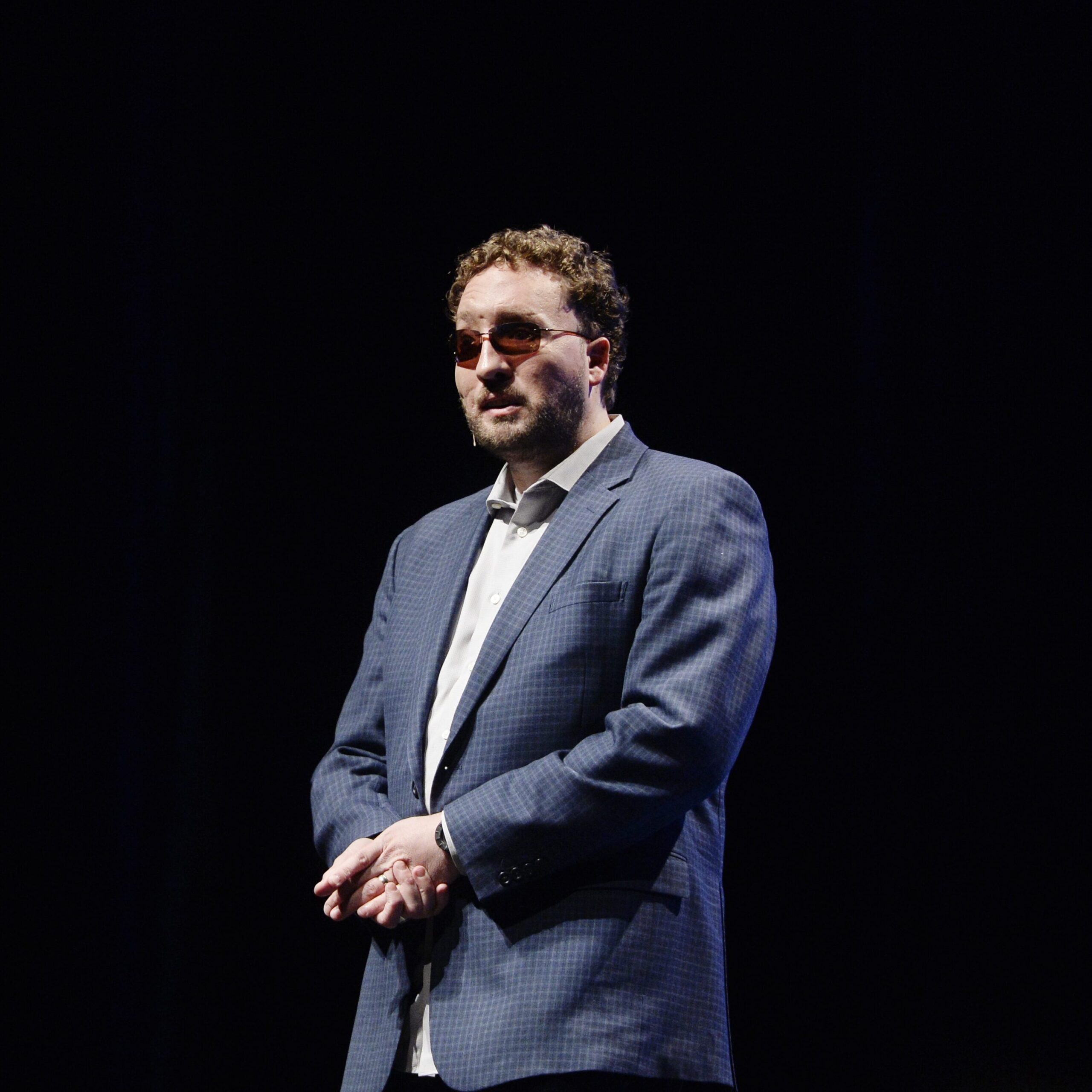 Marcus Engel stands on stage looking out at the audience.