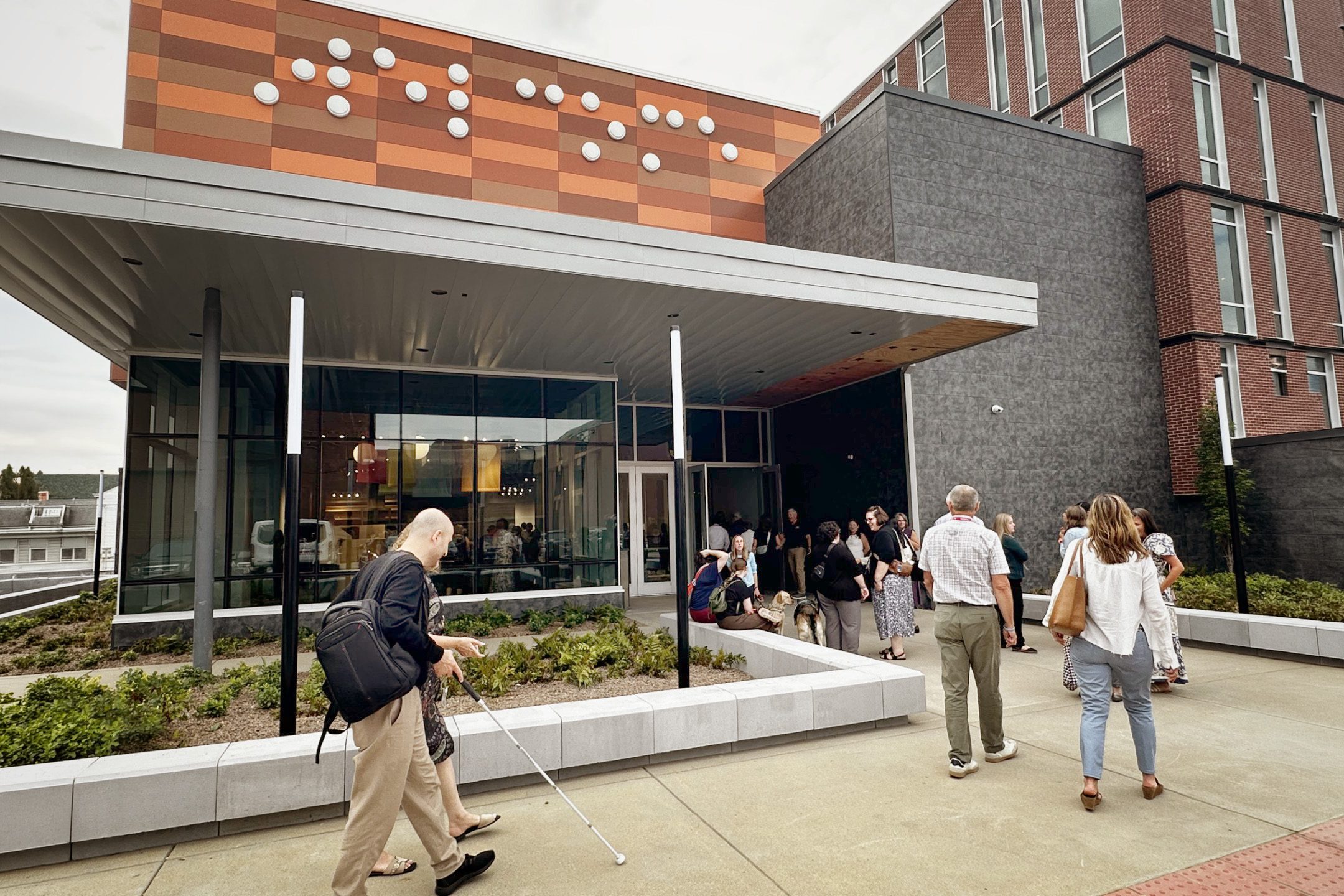 A group of people walk into the front entrance of The Dot Experience at American Printing House